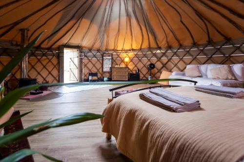 a bedroom in a yurt with a bed and a couch at JOY Retreat in Isle of Jersey