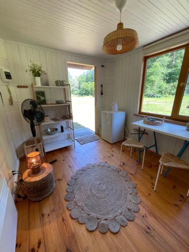 a room with a table and a rug on a wooden floor at Vaide kempings in Vaide