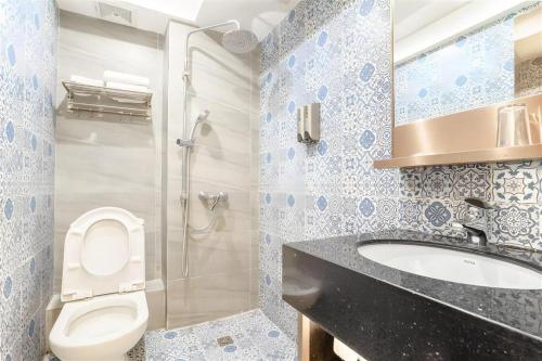 a bathroom with a toilet and a sink and a shower at Hou Kong Hotel in Macau