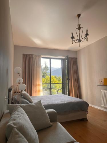 a bedroom with a bed and a large window at Luxury Residence Likani in Borjomi