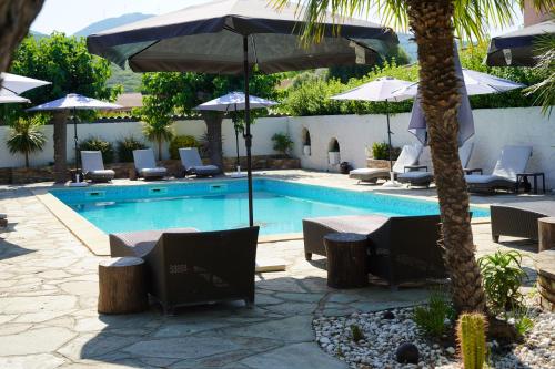 a pool with chairs and umbrellas next to a resort at Stella Marina in Macinaggio
