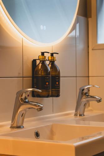 a bathroom sink with two soap dispensers on it at Stijlvol 4-6 pers "Vakantiehuis De Meierij" - compleet ingericht huis met vrij weidezicht in Schijndel