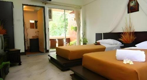 a bedroom with two beds and a large window at Baan Pim in Chiang Mai
