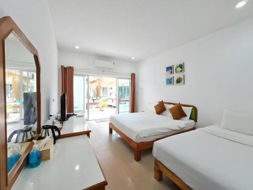 a bedroom with two beds and a television in it at Sawasdee Coco Resort in Ko Samed
