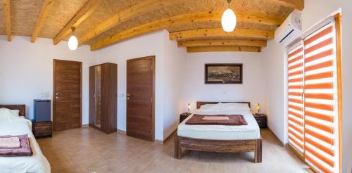 a bedroom with two beds and a wooden ceiling at Motel Orhideja in Donji Vakuf