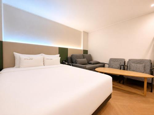 a bedroom with a bed and a table and chairs at Hotel Yaja Gwangalli in Busan