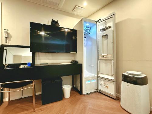a room with a desk with a microwave and a refrigerator at Hotel Yaja Gwangalli in Busan