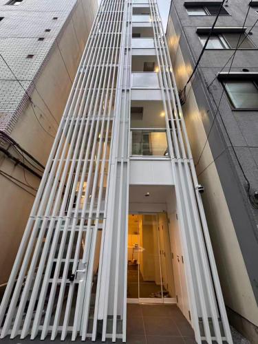 a ladder leading up to a tall building at MARUKOUHOTEL 入船 inn in Tokyo