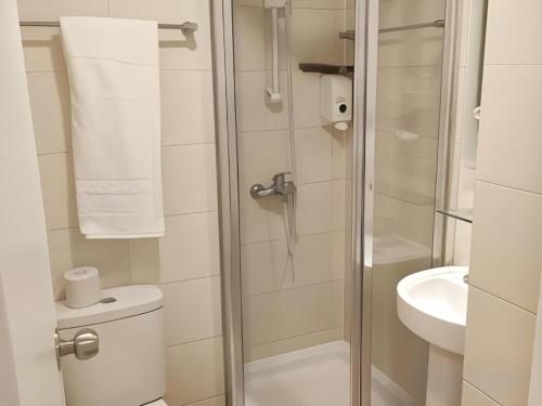 a bathroom with a shower with a toilet and a sink at Goodrich Hotel in Hong Kong