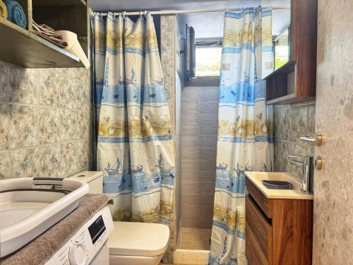 a bathroom with a toilet and a shower curtain at Maria's Seafront Villa in Loutra Edipsou