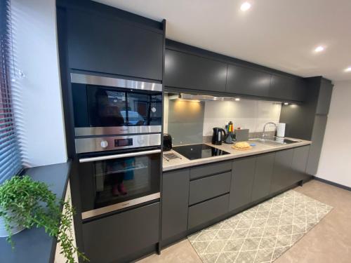 a kitchen with black cabinets and stainless steel appliances at The Courtyard Apartment, Brampton Town Centre, Hadrians Wall - Sleeps 2 in Brampton