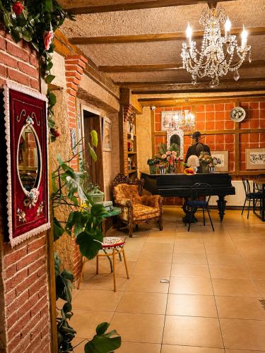 a living room with a piano and a man in the background at Hotel Kalanga in Tbilisi City