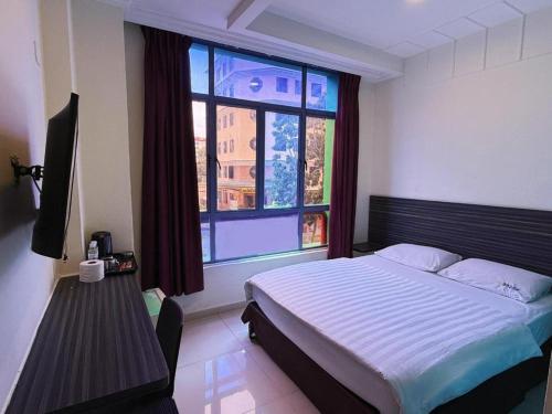 a bedroom with a bed and a large window at Darlene Hotel in Singapore