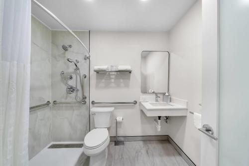a bathroom with a toilet and a shower and a sink at Clarion Pointe Kent - Seattle South in Kent