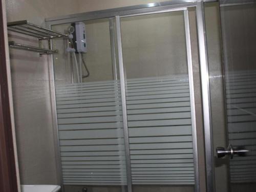 a shower with a glass door in a bathroom at Cherry Midtown Hotel in Bahac-bahac