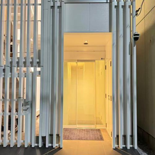 a hallway with white columns and a yellow door at MARUKOUHOTEL 入船 inn in Tokyo