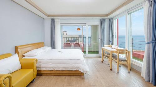 a bedroom with a bed and a view of the ocean at Gangneung Glad Pension in Gangneung