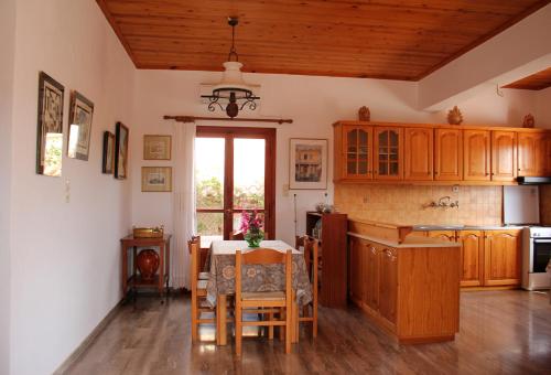 a kitchen with wooden cabinets and a table with chairs at Theros Beach House in Stavros