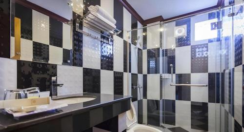 a bathroom with a black and white tiled wall at The Mou Hotel in Phnom Penh