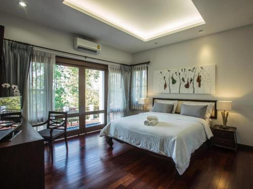 a bedroom with a bed with a teddy bear on it at Doltara Boutique Resort in Chiang Mai