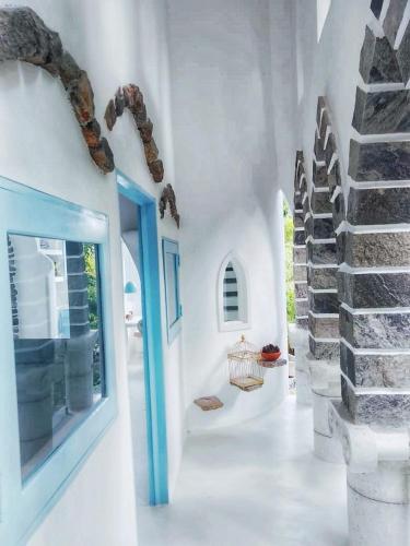 a white room with a blue door and a staircase at La Casa del Sol in Kandy
