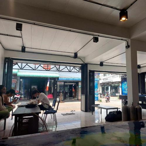 two people sitting at a table in a building at Czone Hostel in Ko Tao