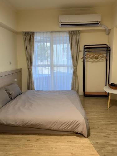 a bedroom with a large bed and a window at 樂室Room in Nanwan