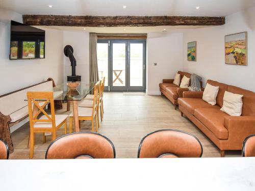 a living room with couches and a table and chairs at Hay Barn in Carnforth