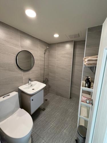 a bathroom with a toilet and a sink and a mirror at 樂室Room in Nanwan
