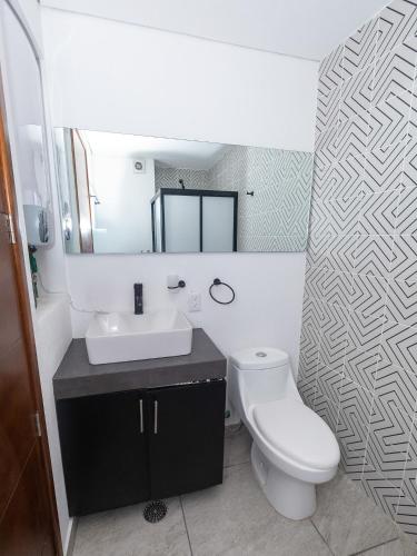a bathroom with a toilet and a sink and a mirror at Loft Reforma in Oaxaca City