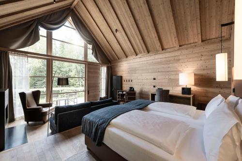 a bedroom with a large bed and a large window at ADLER Ritten in Soprabolzano
