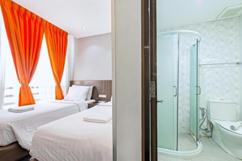 a bedroom with two beds and a glass shower at Eighty Eight Hotel in Koronadal
