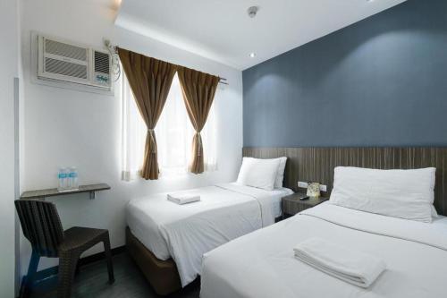 a hotel room with two beds and a window at Eighty Eight Hotel in Koronadal