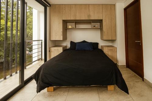 a bedroom with a bed in a room with a window at Loft Reforma in Oaxaca City