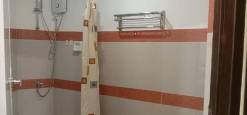 a bathroom with a shower with red and white stripes at Dino Residences in Daro