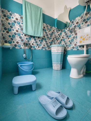 a blue bathroom with a toilet and a stool at Derban guest house in Srinagar