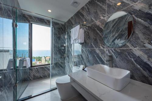 a bathroom with a sink and a mirror at Maison Hotel Phu Quoc in Phú Quốc