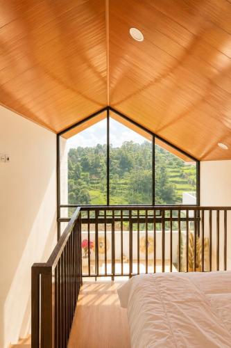 a bedroom with a large window in a house at Villa With Jacuzzi, Damar Ningrum 3 in Tutugan