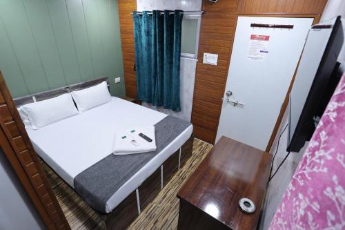 a small room with a bed and a table at FabHotels Rovio in Visakhapatnam