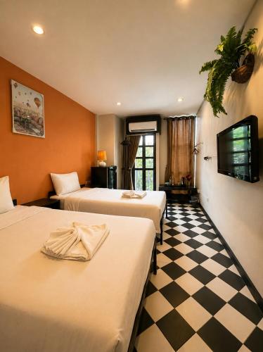 a hotel room with two beds and a checkered floor at SaintLove Hotel in Chiang Mai