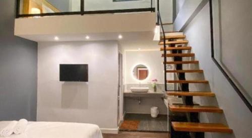 a staircase leading up to a bedroom with a bathroom at Need a Nap Hostel Phrae in Phrae