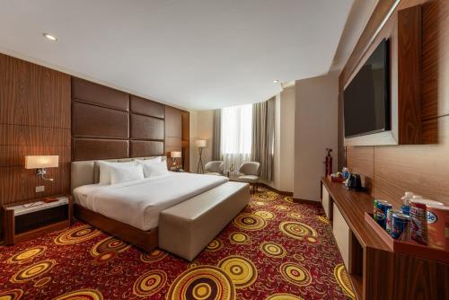 a hotel room with a bed and a flat screen tv at Van Phat Riverside Hotel in Can Tho