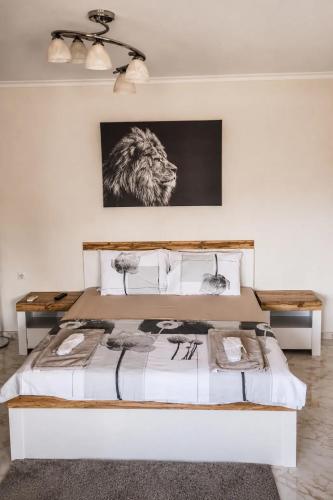 a bedroom with a large white bed with a picture on the wall at Medius Park Apartment in Sandanski