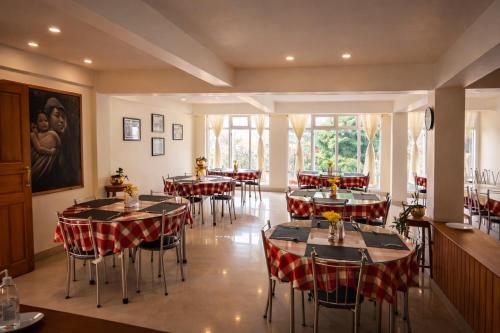 a restaurant with tables and chairs in a room at Shikher Guest House in Kalimpong