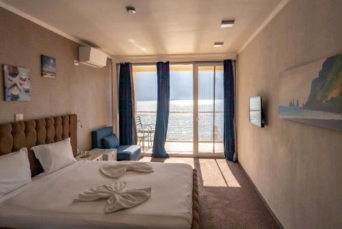 a bedroom with a bed with a view of the ocean at La Vella Resort in Dubova