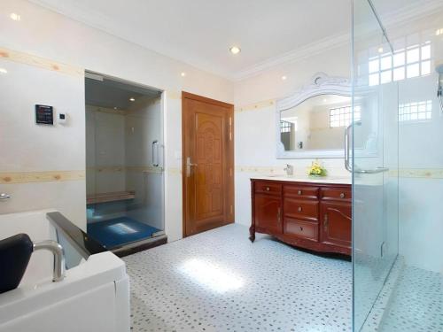 a bathroom with a shower and a sink and a mirror at Jun Yue Hotel in Phnom Penh