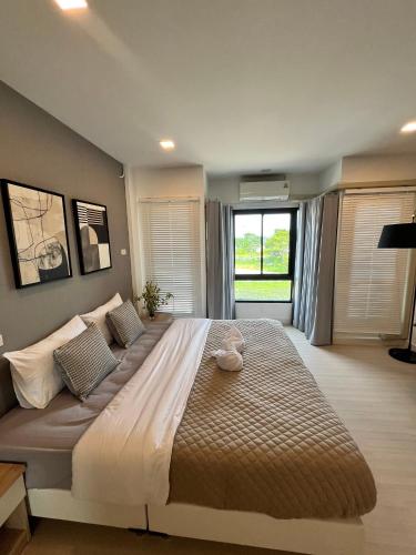 a large bed in a bedroom with a large window at The Eiffel Cafe and Hotel in Ban Khlong Lat Bua Khao