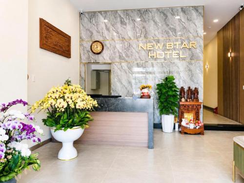 a lobby with a new star hotel sign and flowers at New Star Hotel Tay Ninh in Tây Ninh