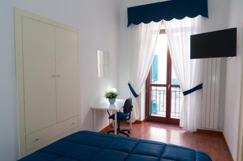 カステッランマーレ・ディ・スタービアにあるLorely's Apartmentのベッドルーム1室(青いベッド1台、デスク、窓付)
