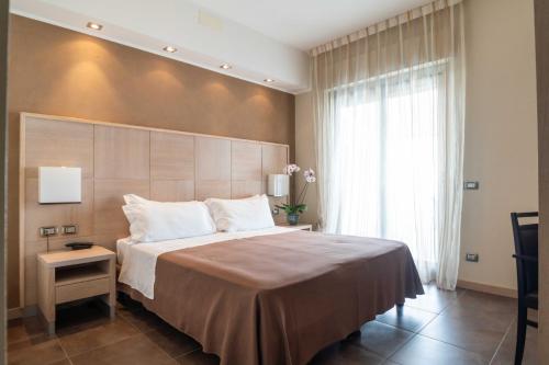 a bedroom with a large bed and a large window at Casa del Mar - Residence & Beach Resort in Roseto degli Abruzzi